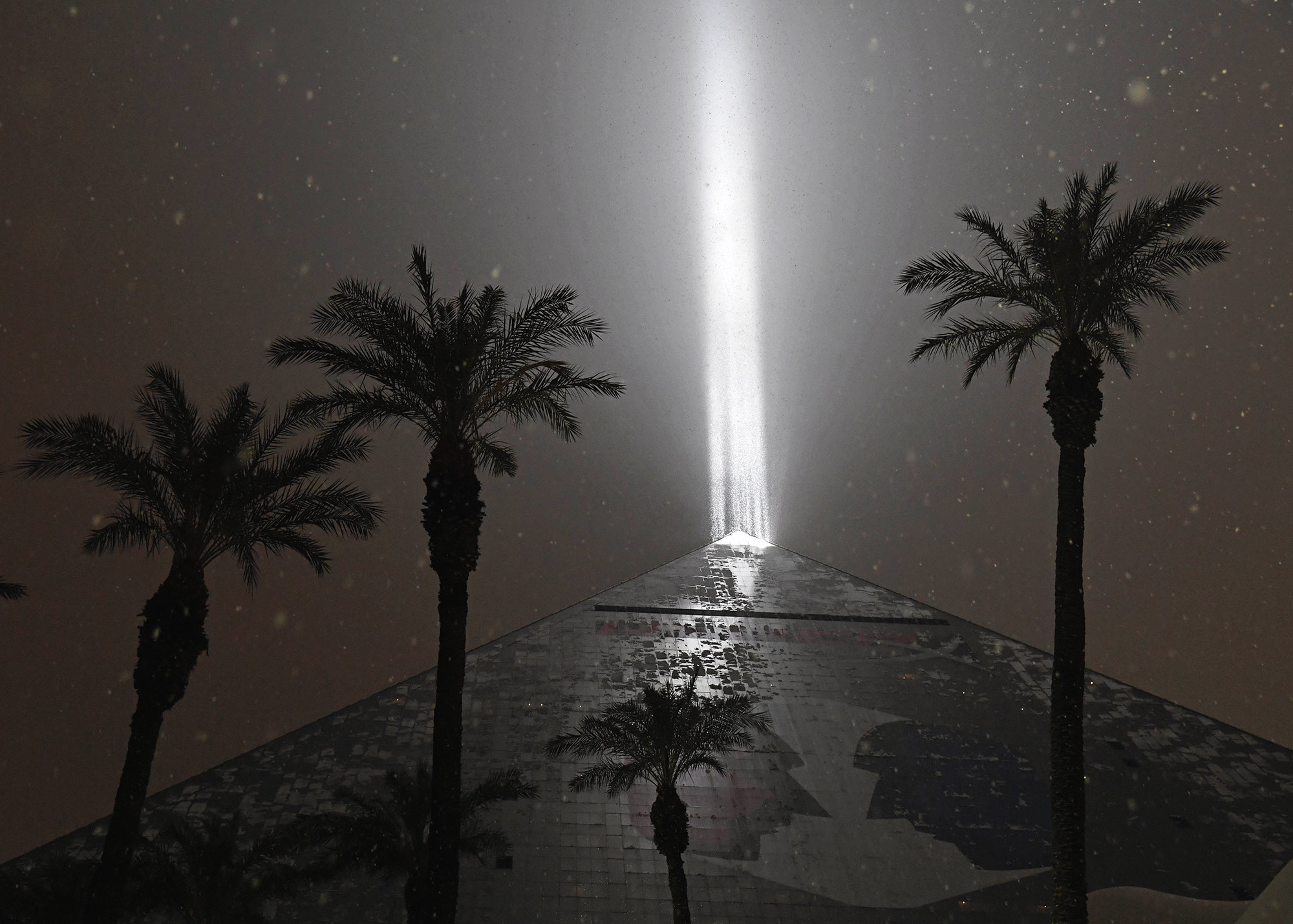 Знаменитый отель Luxor в Лас-Вегасе известен не только своей формой в виде египетской пирамиды, но и тем, что с крыши здания в небо направлен мощный луч света (источник света на крыше считается одним из самых сильных в мире). На этой фотографии луч Люксора освещает редкий для штата Невада снег. Знаменитый отель Luxor в Лас-Вегасе известен не только своей формой в виде египетской пирамиды, но и тем, что с крыши здания в небо направлен мощный луч света (источник света на крыше считается одним из самых сильных в мире). На этой фотографии луч Люксора освещает редкий для штата Невада снег.